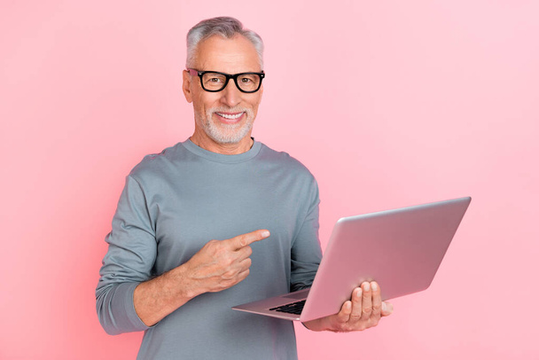 Photo of pretty cute retired man wear grey shirt spectacles pointing modern gadget isolated pink color background - Foto, Imagem