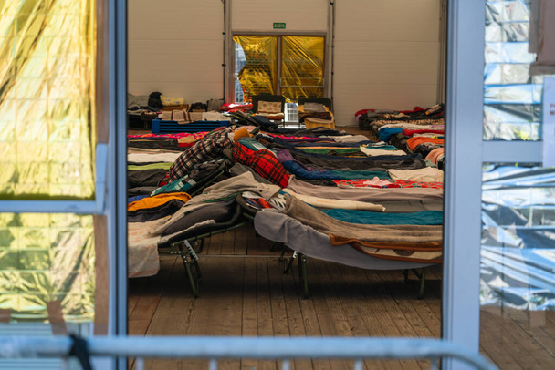 Temporary beds in a camp for refugees from Ukraine in Krakow, Poland. Temporary shelter for Ukrainian women and children fleeing the war in Ukraine - Photo, Image