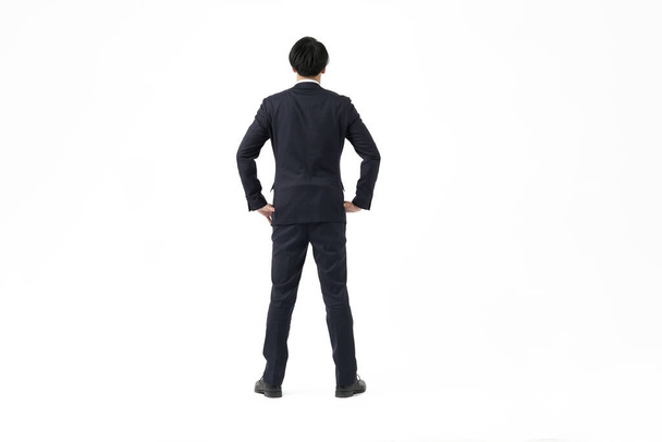 Ένας Ασιάτης επιχειρηματίας που κοιτάζει πίσω και σηκώνεται - Φωτογραφία, εικόνα