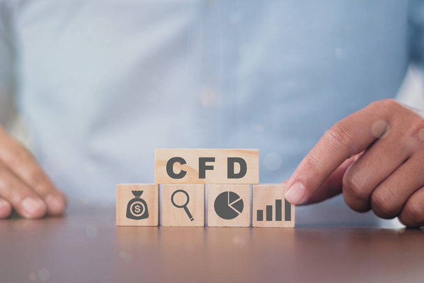 Деловой человек ставит деревянный куб с иконой успеха CFD. Контракт на финансирование разницы технологии фондового рынка. - Фото, изображение