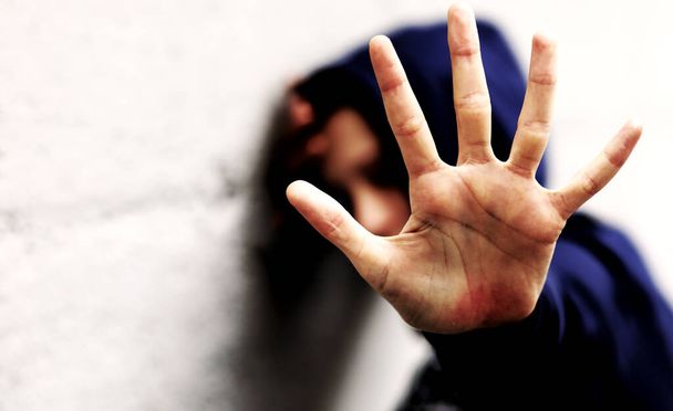 Hand des jungen Mädchens, das versucht, sich vor Gewalt mit dramatischer Wirkung zu schützen - Foto, Bild