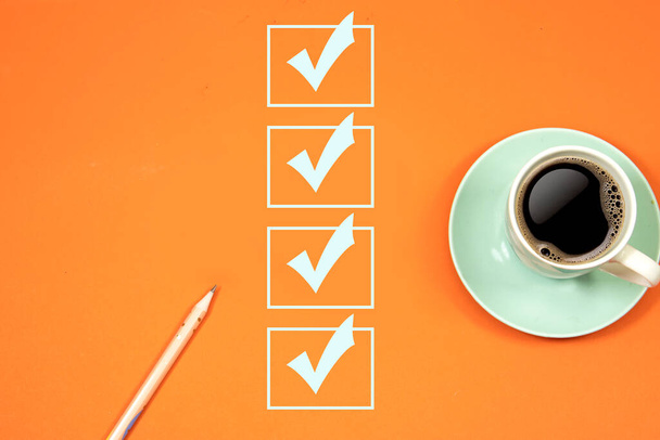 marcação na caixa de seleção. Conceito Checklist, lápis rosa com xícara de café em fundo laranja - Foto, Imagem