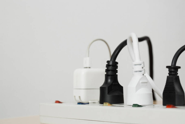 Electrical appliances plugs full of all plugs or plugs together. Because of the risk of causing a short circuit from high heat accumulated in the wires. - Фото, изображение