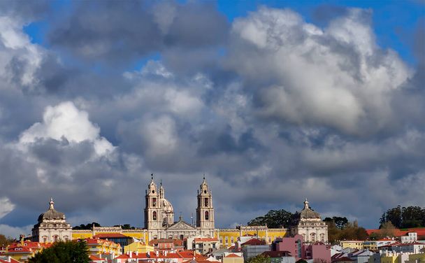Άποψη μιας μακρινής πόλης με έναν καθεδρικό ναό και καθορισμένα σύννεφα - Φωτογραφία, εικόνα