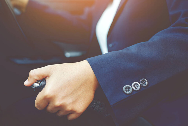 Крупный план человека рука тянет ручной рычаг в машине для безопасности во время парковки
. - Фото, изображение