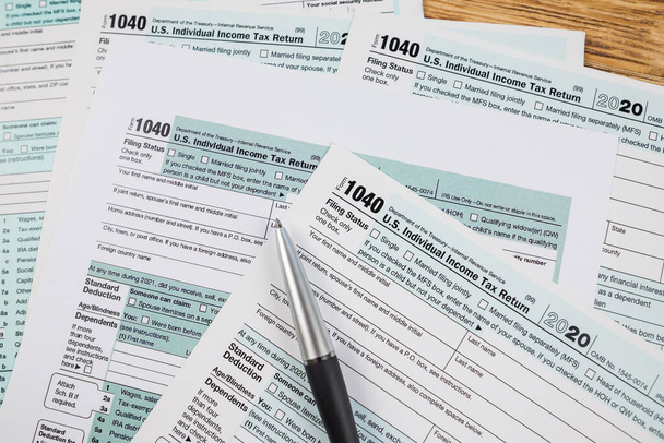 formulários de imposto 1040 com uma caneta em uma mesa de madeira. Vista de cima. documento financeiro. - Foto, Imagem