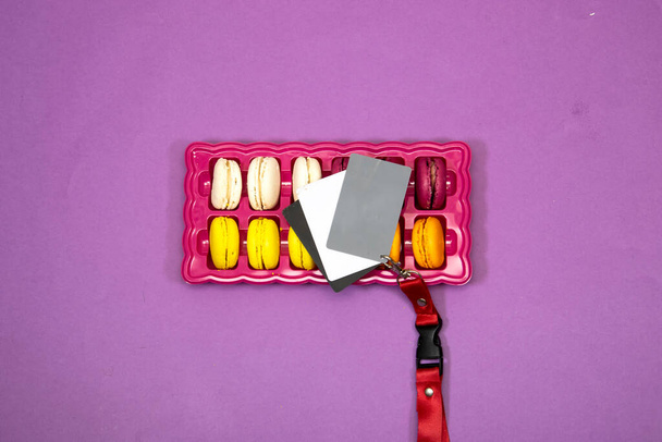 cinturino rosso sopra francese colorato Macarons Cookies, uno strumento fotografi, determinare il corretto bilanciamento del bianco - Foto, immagini