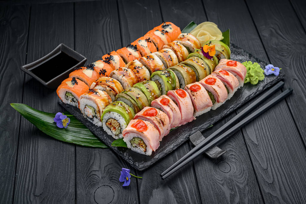 Japanische Sushi-Brötchen im Restaurant. California Sushi Roll Set mit Lachs, Gemüse, fliegendem Fischrogen und Kaviar in Nahaufnahme. Speisekarte japanischer Restaurants - Foto, Bild