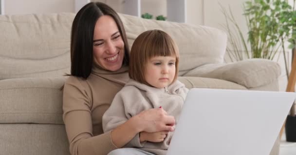 Evde dizüstü bilgisayar kullanan oyuncu bir anne ve kız. - Video, Çekim