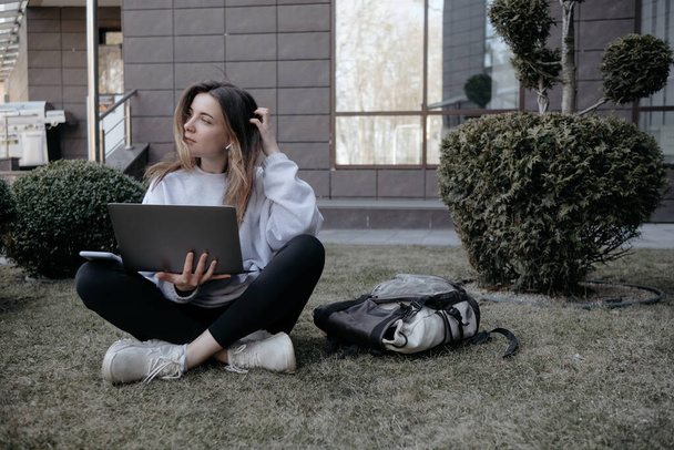 Praca na świeżym powietrzu. Kobieta pracująca na laptopie w parku. Odległej pracy zdalnej podczas kwarantanny coronavirus covid-19. Student uczący się online. Blogger wideo robi transmisję na żywo. - Zdjęcie, obraz