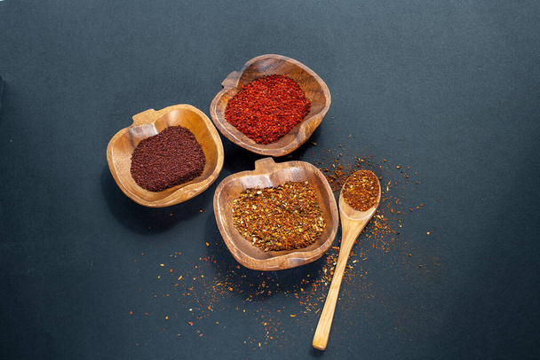 Spices in bowls on black background - Foto, imagen