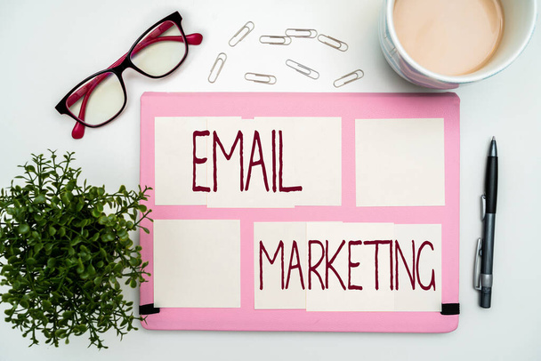 Sign displaying Email Marketing. Word for Sending a commercial message to a group of showing using mail Office Supplies Over Desk With Keyboard And Glasses And Coffee Cup For Working. - Photo, Image