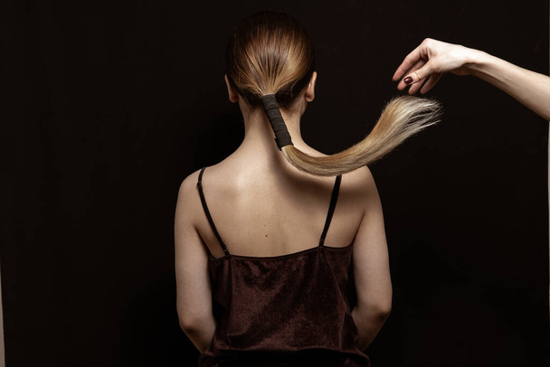 Όμορφα λαμπερά και καθαρά μαλλιά, τακτοποιημένο χτένισμα σε μαύρο φόντο  - Φωτογραφία, εικόνα