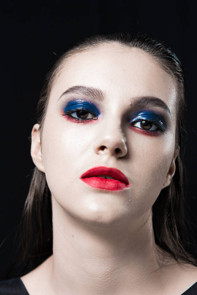 Creative Beauty Portrait with Red Lips and Blue Eyes on a Black Background  - Fotó, kép