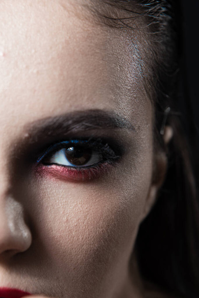 Portrait de beauté créatif avec lèvres rouges et yeux bleus sur fond noir  - Photo, image