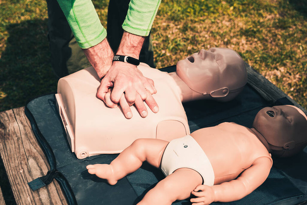 чоловік вчить непрямий масаж серця на манекенах, на симуляторі для надання першої допомоги жертвам, базовий екстрений тренінг
 - Фото, зображення