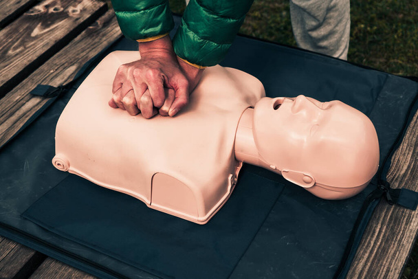man teaches indirect heart massage on mannequins, on the simulator for first aid for victims, basic emergency training - Photo, image