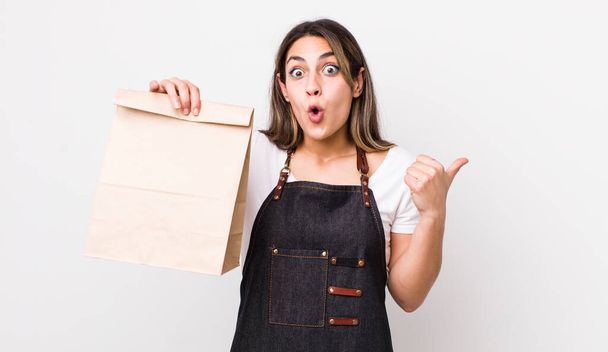 pretty hispanic woman looking astonished in disbelief. delivery and take away concept - Fotó, kép