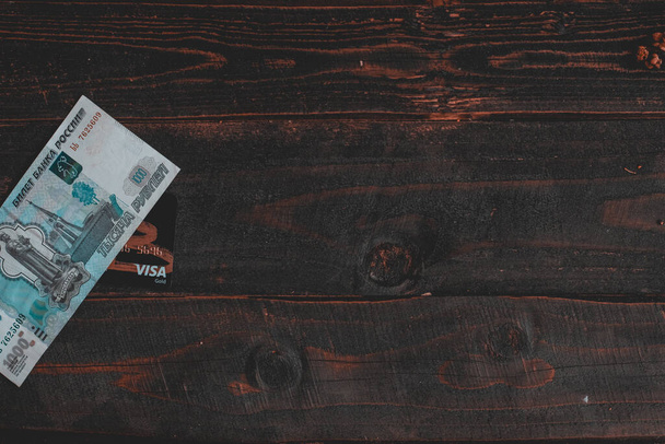 Monnaie russe, Rouble russe, billet de banque en rouble et carte Visa sur carton en bois. Papier peint affaires et finance. Erevan, Arménie - 2022 26 mars: - Photo, image