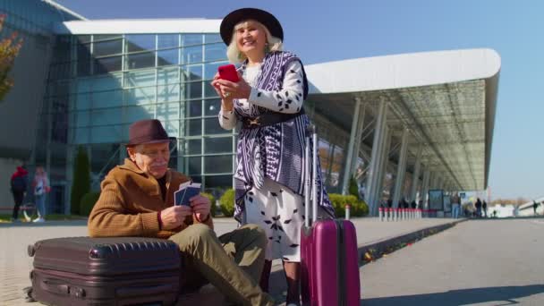 Starszy emeryt turystów babcia dziadek czeka na pokład w pobliżu międzynarodowego hali lotniska - Materiał filmowy, wideo