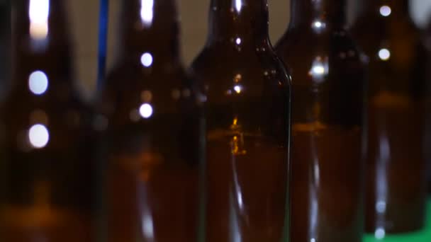 Cervejaria numa casa de campo. Garrafas de cerveja marrom são cheias de cerveja fresca - Filmagem, Vídeo