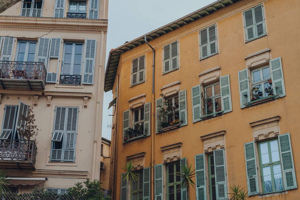 Exterior de un edificio residencial tradicional en Niza, Francia, plantas en las ventanas. - Foto, Imagen