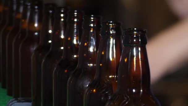 Cervecería en una casa de campo. Las botellas de cerveza marrón están llenas de cerveza fresca - Imágenes, Vídeo