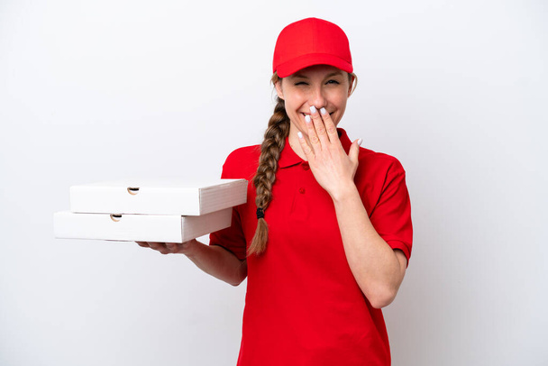 mujer de entrega de pizza con uniforme de trabajo recogiendo cajas de pizza aisladas sobre fondo blanco feliz y sonriente boca cubierta con la mano - Foto, Imagen