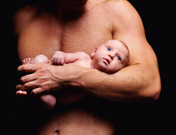 μικροσκοπικό νεογέννητο μωρό στο χέρι του πατέρα του ισχυρή - Φωτογραφία, εικόνα