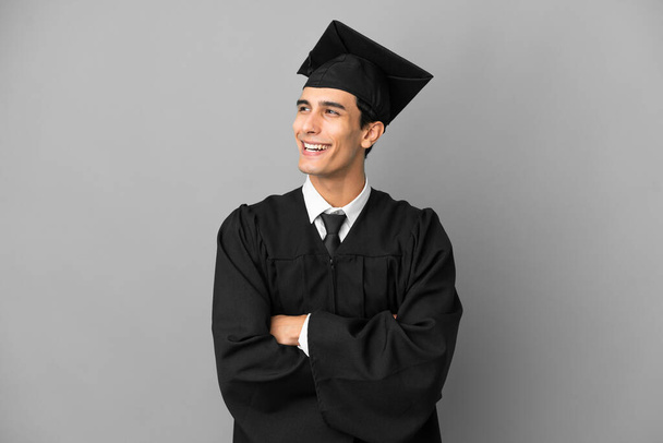 Młody argentyński absolwent uniwersytetu odizolowany na szarym tle szczęśliwy i uśmiechnięty - Zdjęcie, obraz