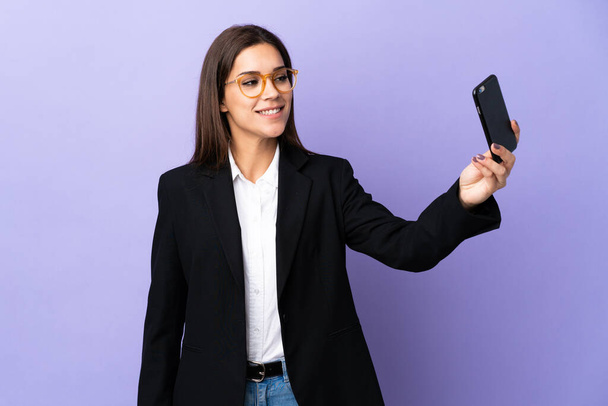 Geschäftsfrau macht auf lila Hintergrund ein Selfie - Foto, Bild