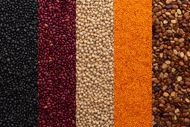 Diferentes tipos de legumbres, garbanzos y lentejas, frijoles rojos, negros y marrones, vista superior - Foto, imagen