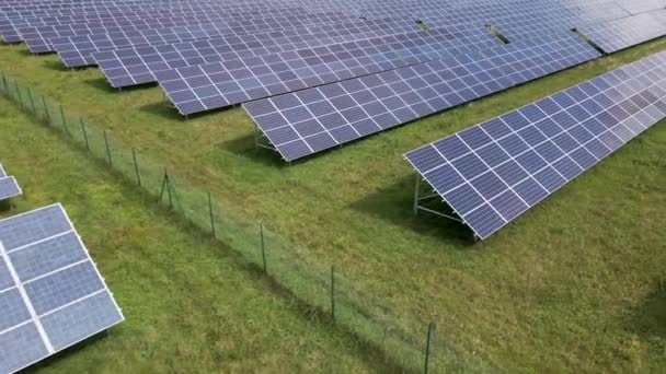 Luchtfoto van een grote duurzame elektriciteitscentrale met rijen fotovoltaïsche zonnepanelen voor de productie van schone elektrische energie. Concept van hernieuwbare elektriciteit zonder uitstoot - Video