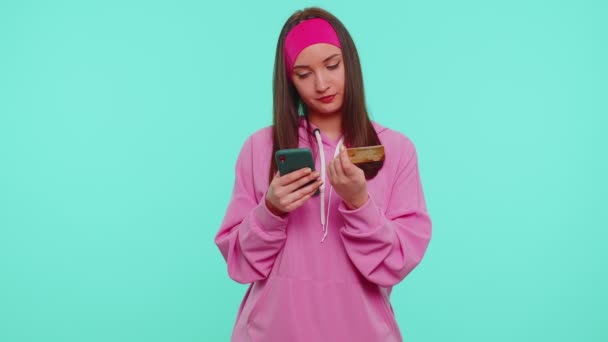Tyttö käyttää matkapuhelin ja muovi luottokortilla selailu sanoa wow kyllä selville iso voitto - Materiaali, video