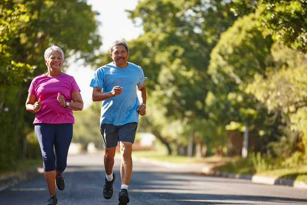 Glück und Gesundheit sind unser Ziel. Schuss eines reifen Paares beim gemeinsamen Joggen an einem sonnigen Tag. - Foto, Bild
