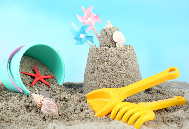 Sandcastle with pinwheel on beach - Фото, зображення