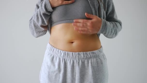 Mujer comprimiendo la piel en su estómago buscando celulitis y exceso de grasa subcutánea - Metraje, vídeo