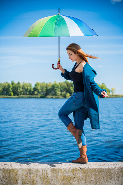 Vonzó fiatal alkalmi lány sétál a parkban esernyővel, ősszel vagy tavasszal. Időjárás és az emberek koncepció - szép hölgy esernyővel a természetben. Anglia eső - Fotó, kép