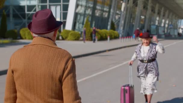 Senior starý manžel a manželka důchodci turisté setkání v letištním terminálu po cestování - Záběry, video