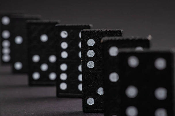 Czarne Domino na ciemnym tle, zbliżenie rozrzucone domino na szarym stole. Gry Gra planszowa, Game Night Dominos tabeli gry. - Zdjęcie, obraz