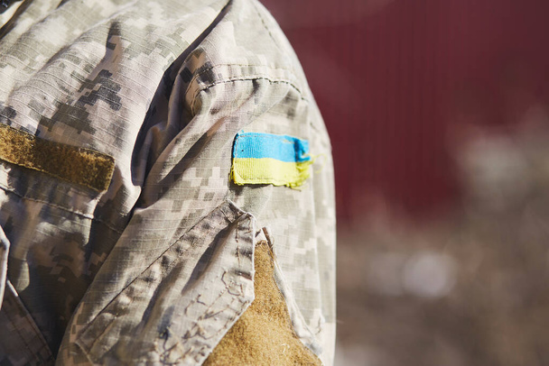 Ukrainian flag on uniform of soldier. Breaking news. Stop russian aggression. Stop war in Ukraine. Stay with Ukraine. Pray for Ukraine. Copy space. - Fotografie, Obrázek