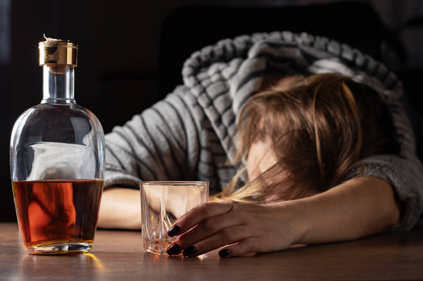 Dronken dronken vrouw in de buurt van whiskey glas slapen, vrouwelijke zware drinker alcoholist flauwgevallen liggend na drank, alcoholisme probleem, alcoholverslaving concept. - Foto, afbeelding