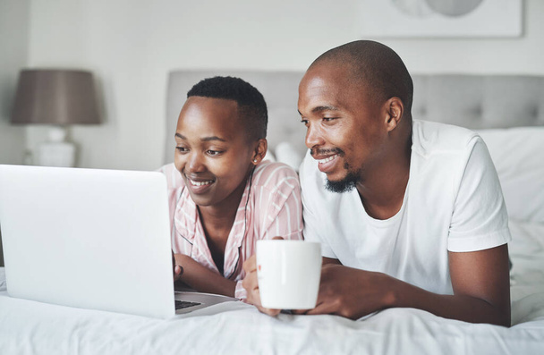 Lo que es casa sin conexión a Internet. Foto de una feliz pareja joven usando un ordenador portátil juntos en el dormitorio en casa. - Foto, Imagen