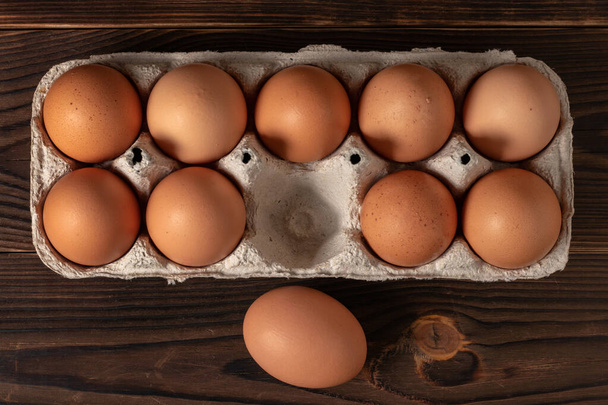 Καλό Πάσχα. Πασχαλινά αυγά. Κοτόπουλο καφέ αυγά closeup top view Στο τραπέζι. Ένα χαρτοκιβώτιο με φρέσκα καφέ αυγά. Βιολογικά αυγά κοτόπουλου σε ένα κουτί αυγών. - Φωτογραφία, εικόνα