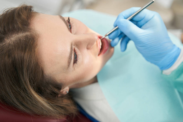 Tandarts controleren vrouw tanden met tandheelkundige spiegel - Foto, afbeelding