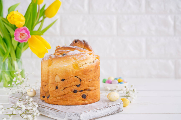 Easter composition. Traditional Russian and Ukrainian Easter cake - Cruffin, Kraffin or Kulich with chocolate and candied fruits on a white wooden background. Paska Easter Bread. Selective focus. Copy space. - Foto, Imagen