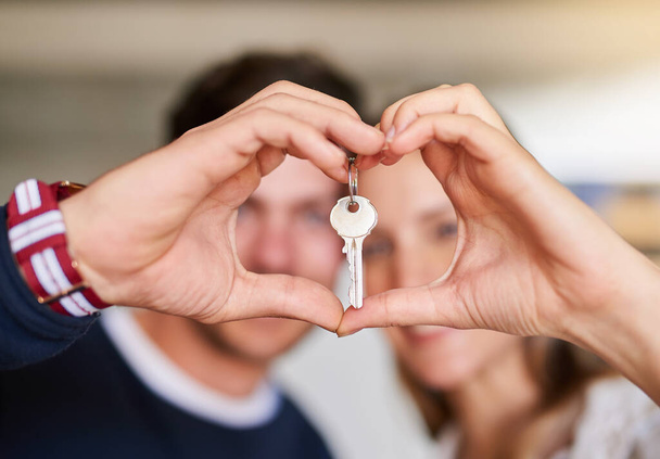 Love starts at home. Portrait of a happy young couple proudly displaying the keys to their new house. - Photo, Image