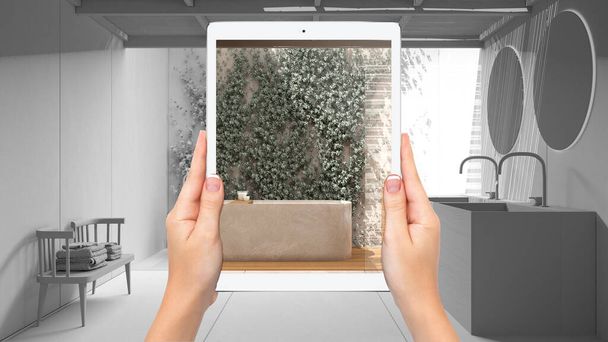 Kädet tilalla tabletti osoittaa moderni kylpyhuone kylpyammeella, yhteensä tyhjä projektin tausta, täydennetty todellisuus käsite, sovellus simuloida huonekaluja ja sisustustuotteita - Valokuva, kuva