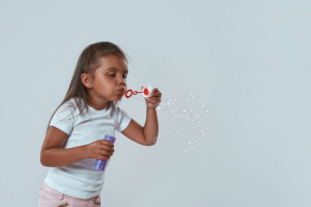 Partial of preschooler girl blowing soap bubbles - Fotó, kép