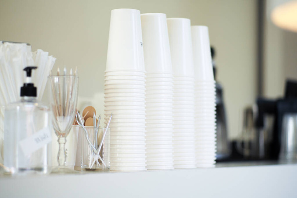 Valikoiva keskittyminen ensimmäiseen pinoon valkoisia paperimukeja pöydällä kahvilassa - Valokuva, kuva